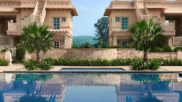 Una piscina al aire libre, sombrillas, tumbonas