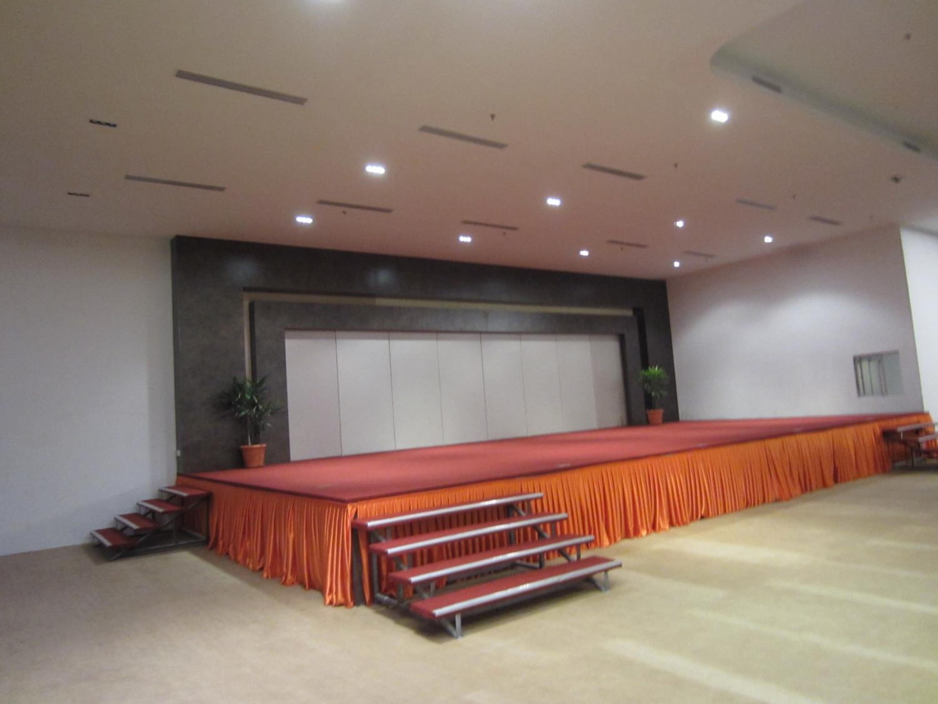 A large conference room with a long table, tiered seating, and a large window.