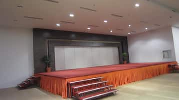 A large conference room with a long table, tiered seating, and a large window.