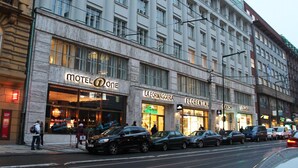 A multi-story hotel with a prominent 'Motel One' sign, a 'La Formaggeria' shop, and 'Florentinum' restaurant. - Motel One Prague-Florentinum (Prague)