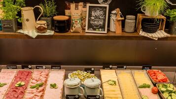 Un buffet proposant une variété de plats, notamment des viandes, des fromages et des légumes.