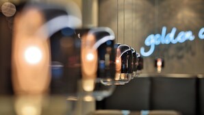 A modern interior with a glass partition and a neon sign reading "golden". - Motel One Prague-Florentinum (Prague)