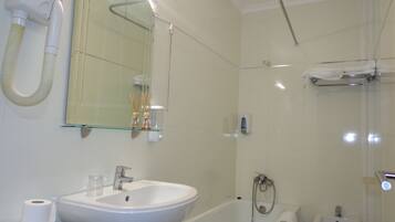Un bagno con lavandino, specchio, doccia e bidet.