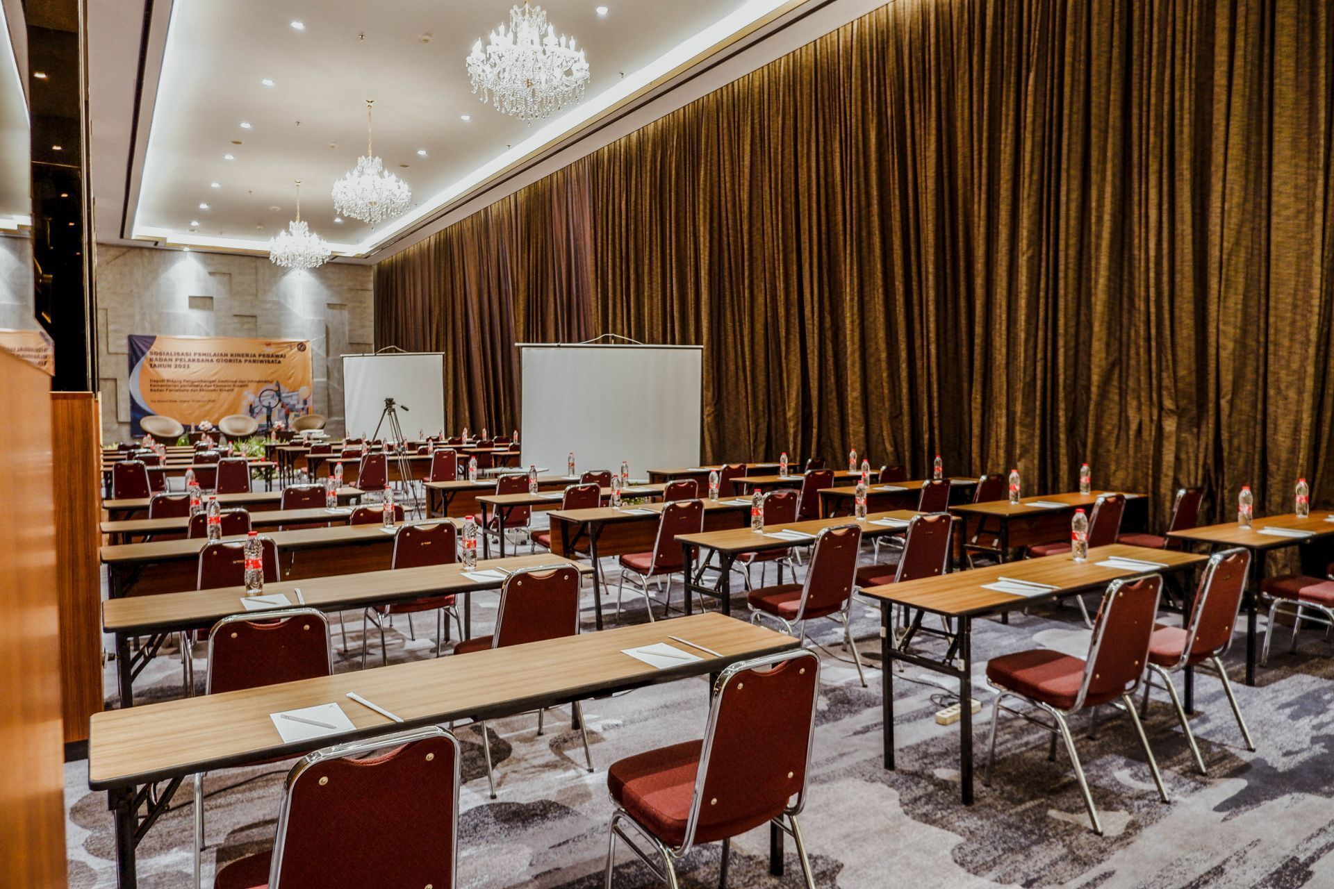 Ein Konferenzraum mit Tischen und Stühlen, einer Tafel und einem Projektor.