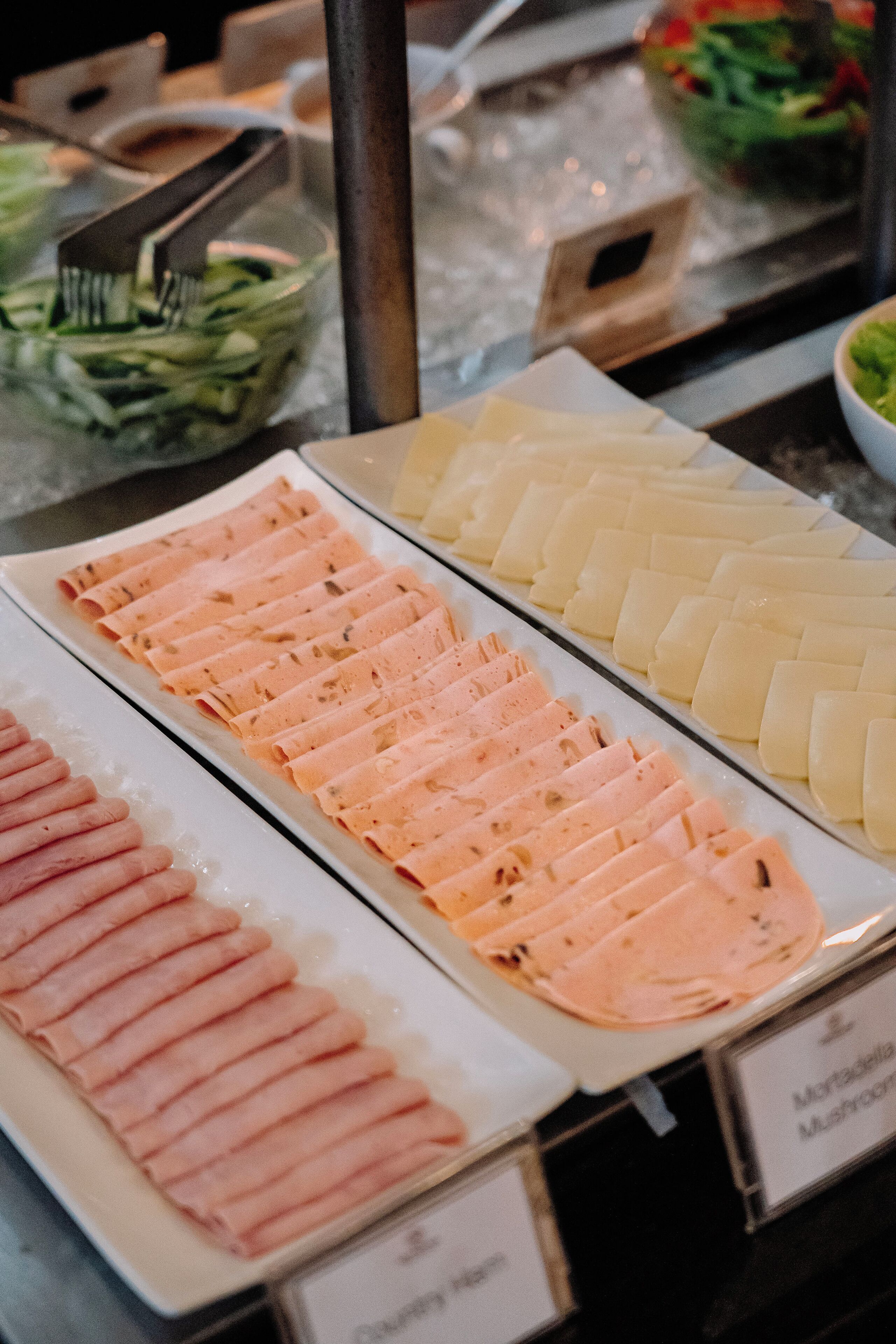 A buffet with neatly arranged food items, including sliced meats and vegetables.
