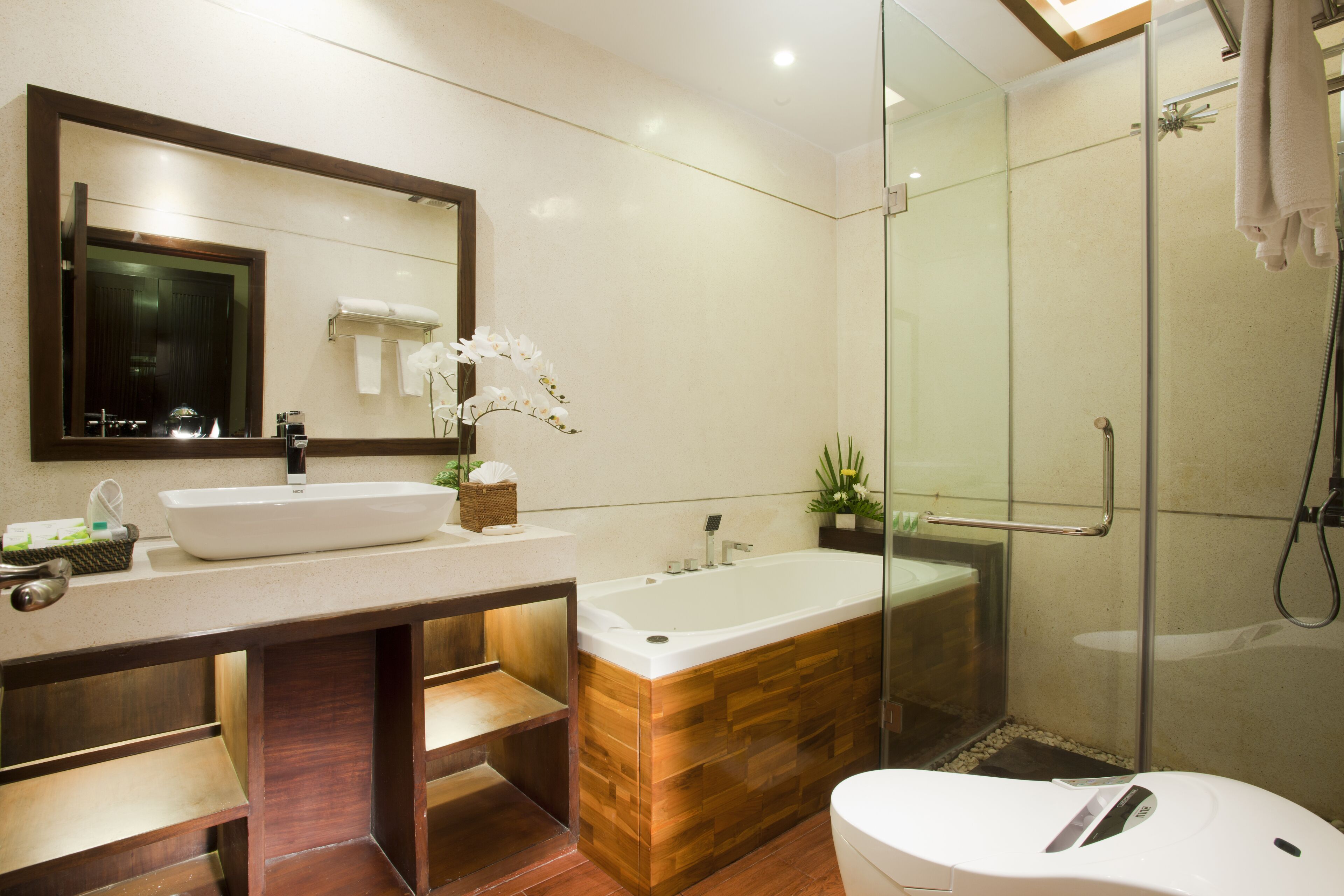 A modern bathroom with a large sink, a freestanding bathtub, and a glass-enclosed shower area.
