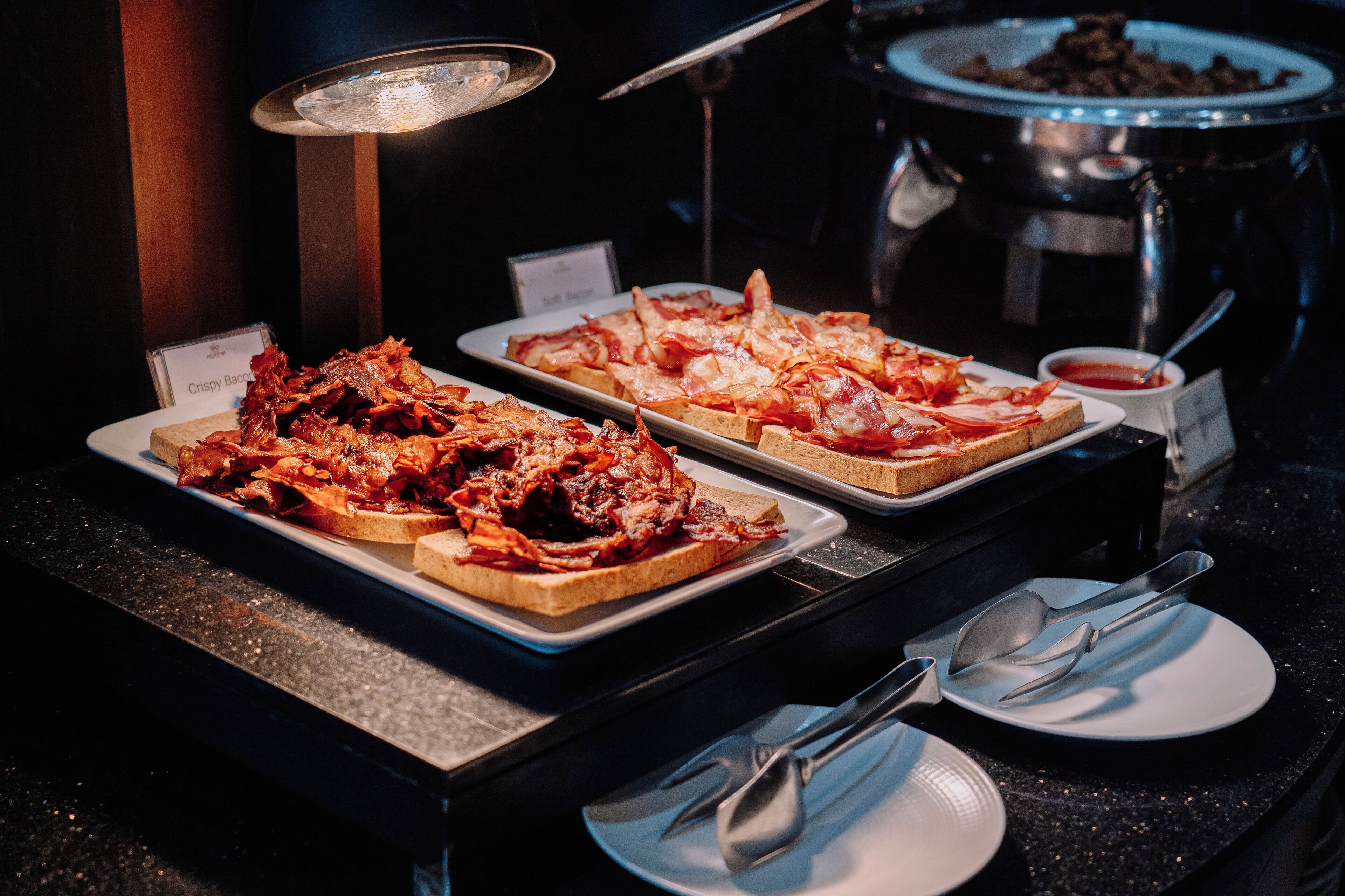 A buffet with crispy bacon and sandwiches.