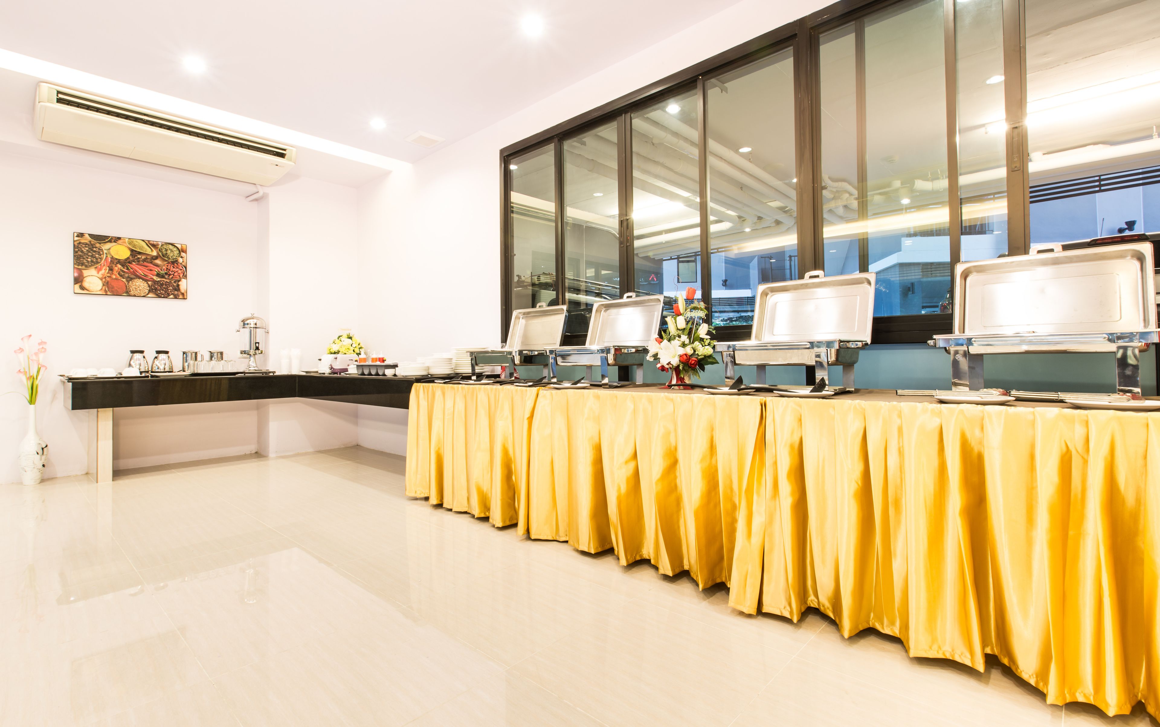 A buffet setup with multiple serving stations, a large window with a view, and a modern interior design.