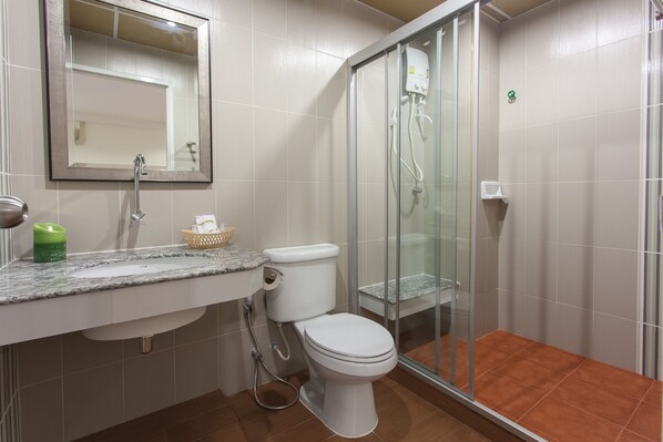 Un baño con inodoro, lavamanos y ducha.