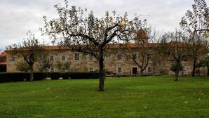 Um edifício de pedra com várias janelas e telhado de telhas vermelhas.