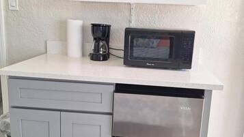 A kitchen with a microwave, coffee maker, and a dishwasher.