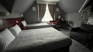 A room with two beds, a desk, a chair, and a couch. - Charlotte Guest House (London)