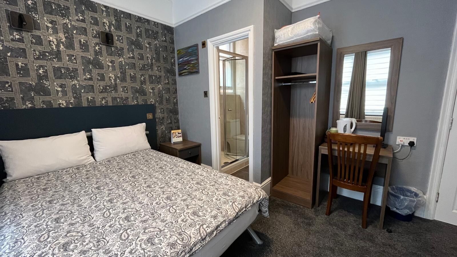 Une chambre à coucher avec un lit, un bureau et un dressing.