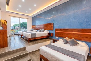 A modern hotel room with two beds, a balcony, and a large window.