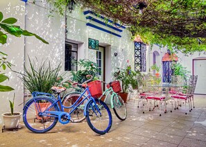 A courtyard with a blue bicycle, potted plants, and a white building with blue trim. - Hotel Dos Lunas - Hostel (Oaxaca)