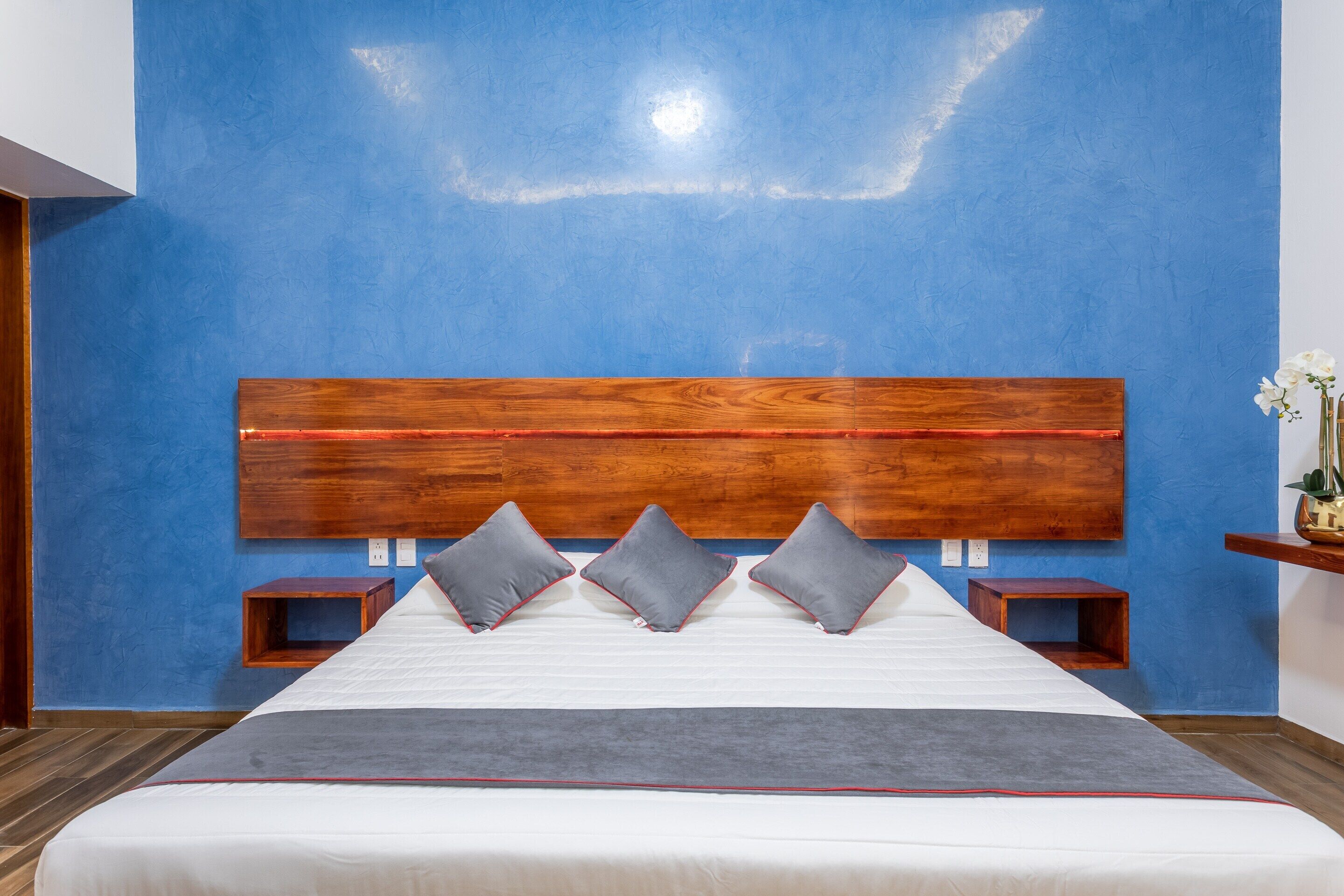 A bedroom with a large bed, a wooden headboard, and two nightstands.