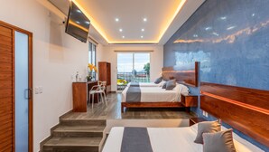 A modern hotel room with a large bed, a desk, and a balcony with a view. - Hotel Dos Lunas - Hostel (Oaxaca)