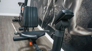Une salle de sport équipée de matériel d’exercice, notamment un banc et une machine de musculation.