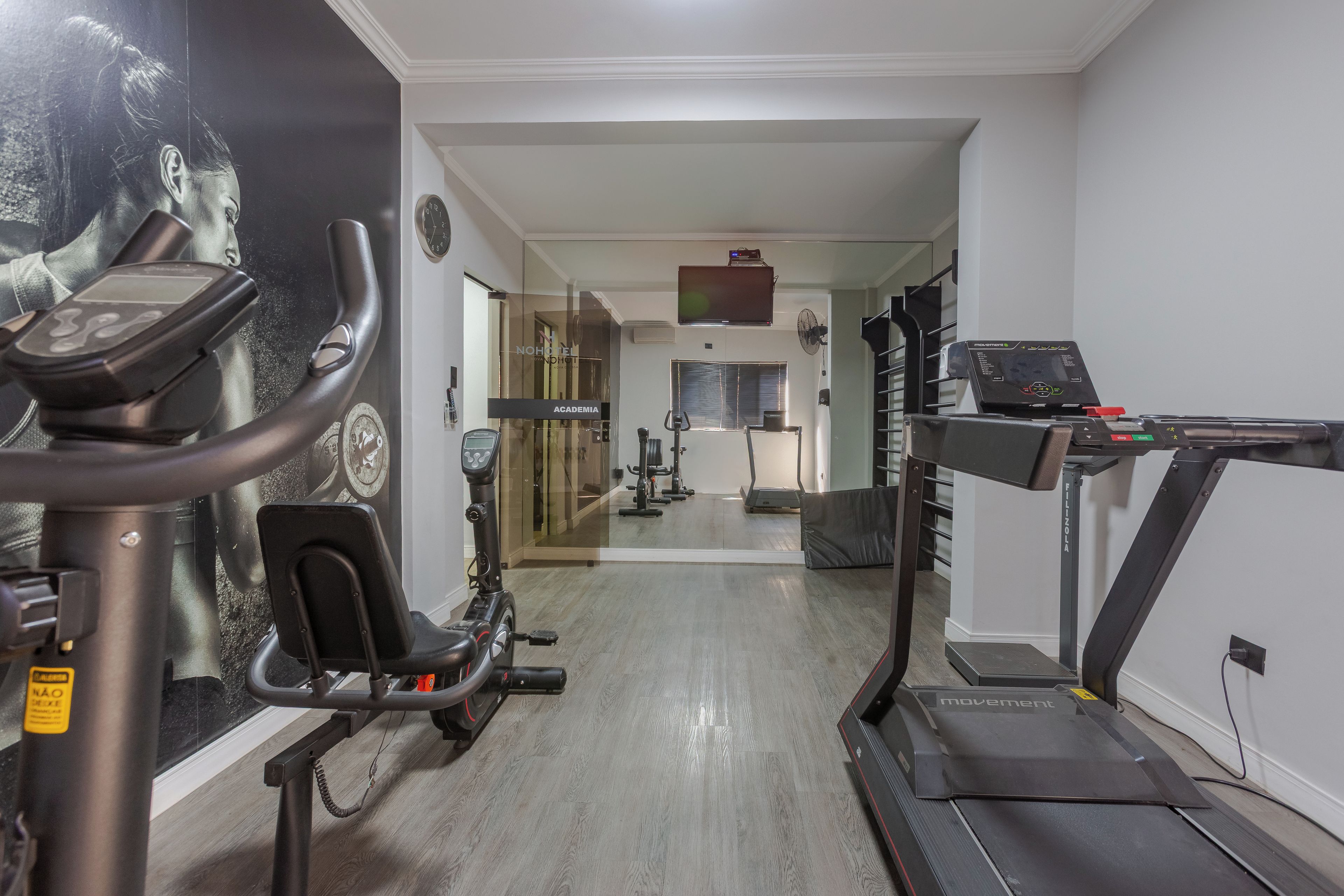 A gym with exercise equipment including treadmills, stationary bikes, and a rowing machine.