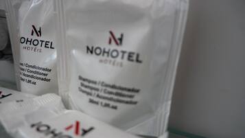 Due sacchetti bianchi con l'etichetta 'NOHOTEL' che indicano contenere shampoo e balsamo.