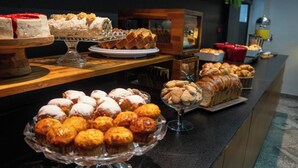 Un bufé con diversas opciones de panadería, incluyendo pasteles y pan.