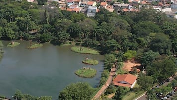 Vista aérea de um bairro residencial com um grande lago rodeado por vegetação exuberante e algumas casas.