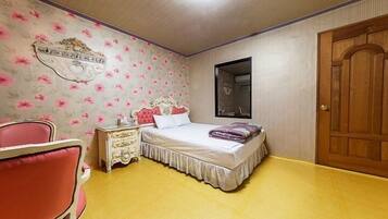A bedroom with a bed, a dresser, a chair, and a wooden door.