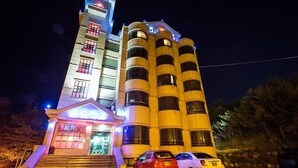 Un hôtel à plusieurs étages, doté d’une entrée imposante et d’un espace de stationnement.