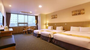 A hotel room with three beds, a desk, and a chair. - Hotel Skypark Jeju 1 (Jeju City)