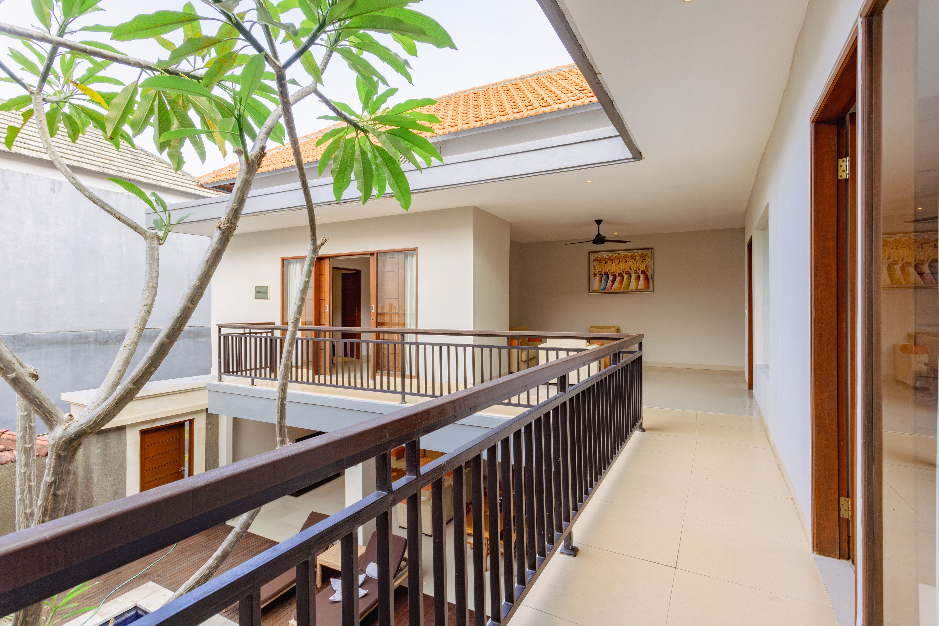 Ein mehrstöckiges Wohngebäude mit Balkon, Ziegeldach und Deckenventilator.