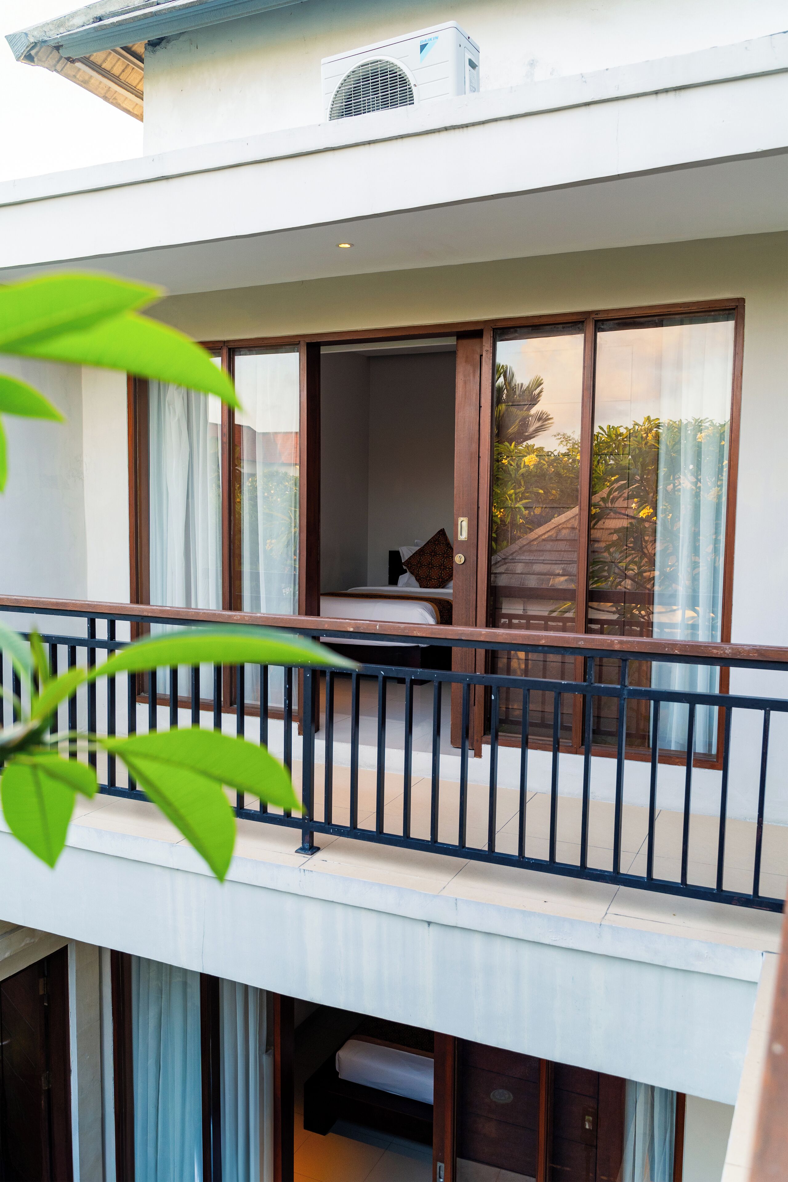 Un balcon avec un lit, des rideaux et une fenêtre.