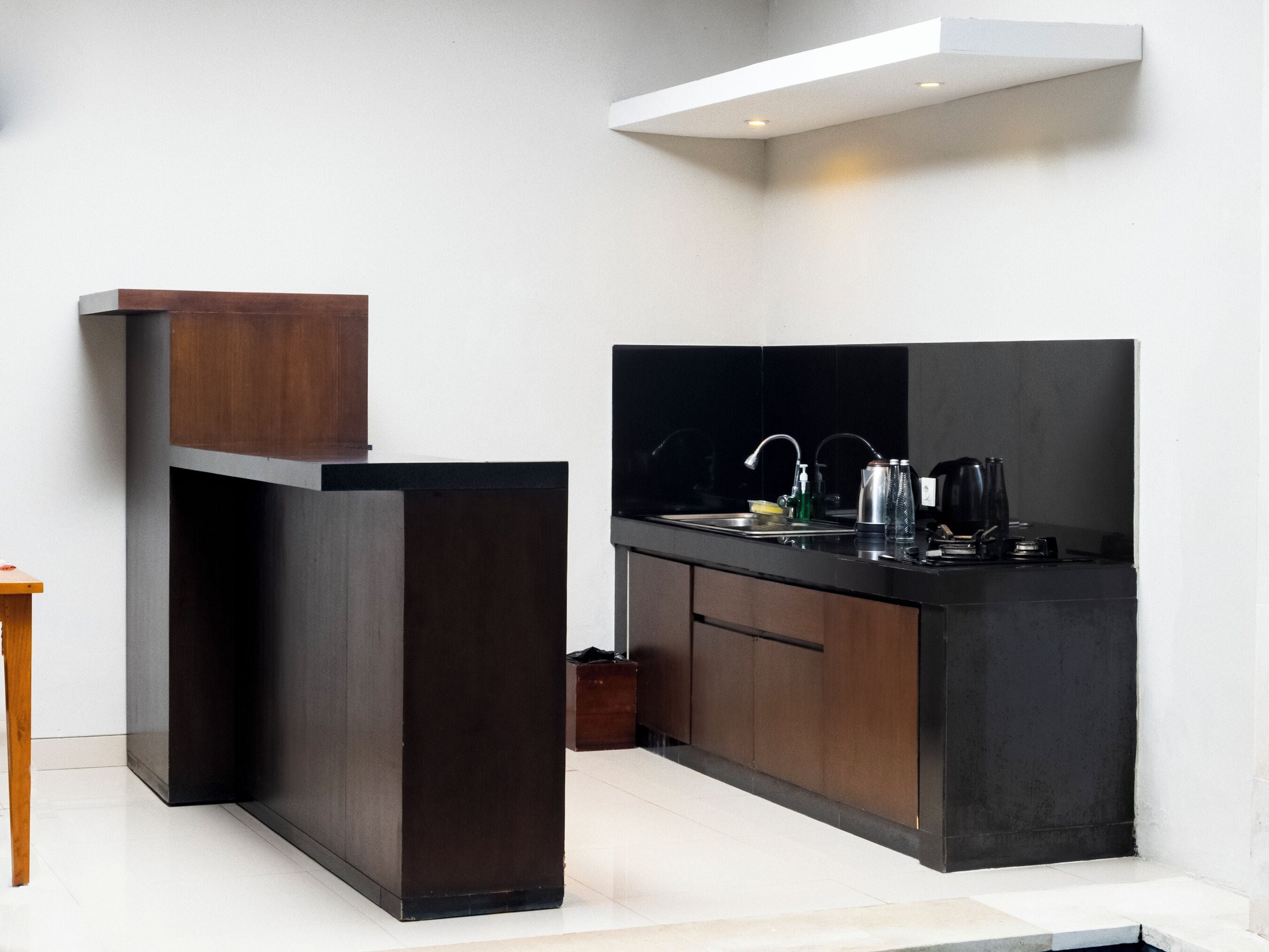 Een moderne keuken met donkere kastjes, een zwart aanrecht en een roestvrijstalen spoelbak.
