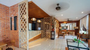 A spacious lobby with a reception desk, seating area, and a dining section. - The Light Exclusive Villas & SPA (Seminyak)