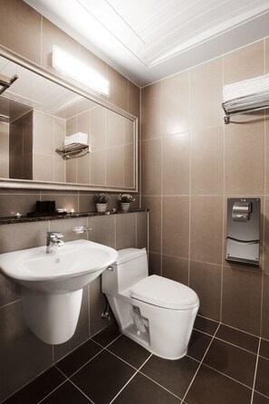 Un baño moderno con lavamanos, inodoro y toallero.