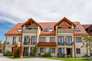 A multi-story residential building with balconies, large windows, and a red-tiled roof. - Landhotel und Gasthaus Wiedmann (Eresing)