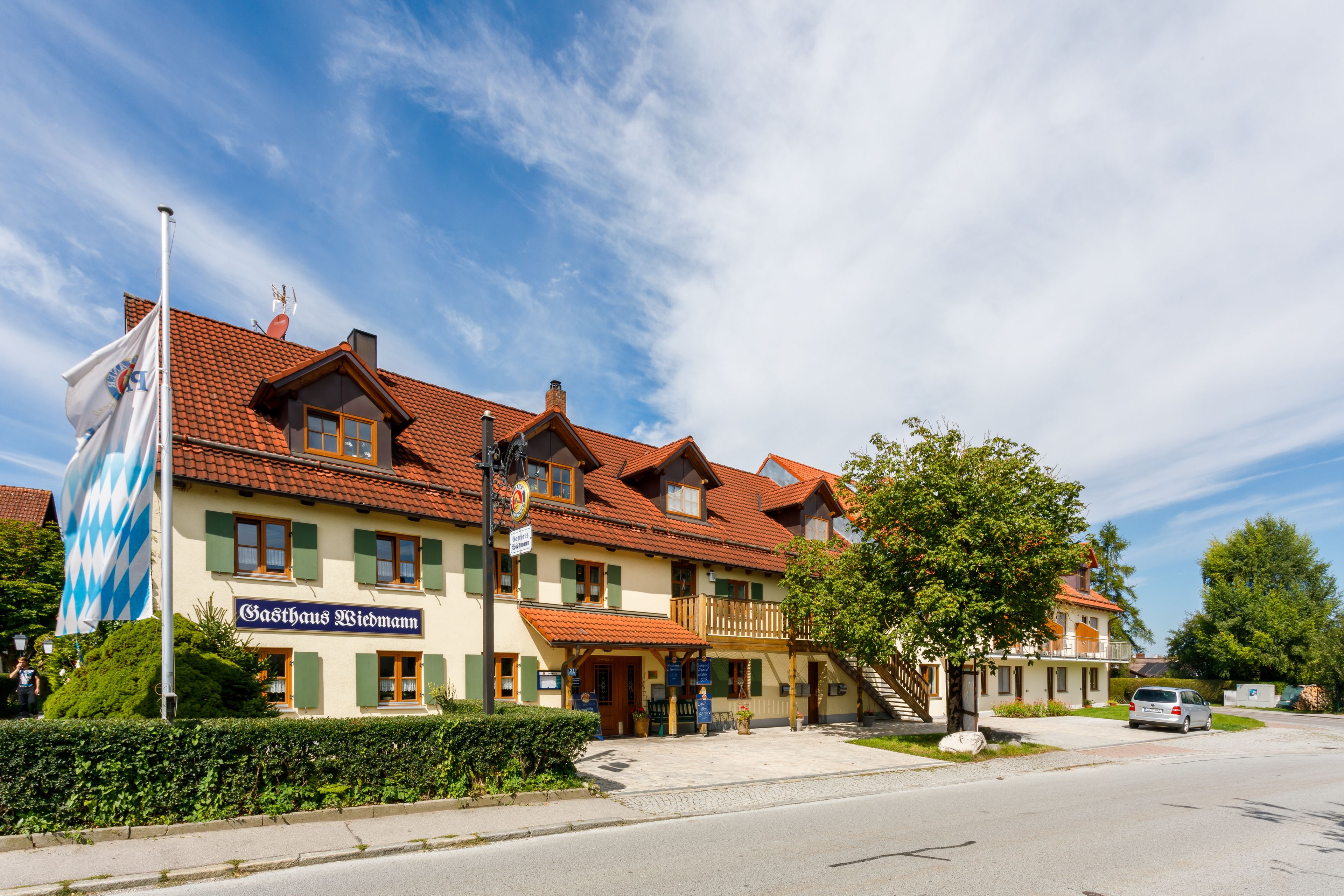 Un bâtiment traditionnel de Bavière, sur lequel on peut lire l’inscription « Gasthaus Wiedemann ».