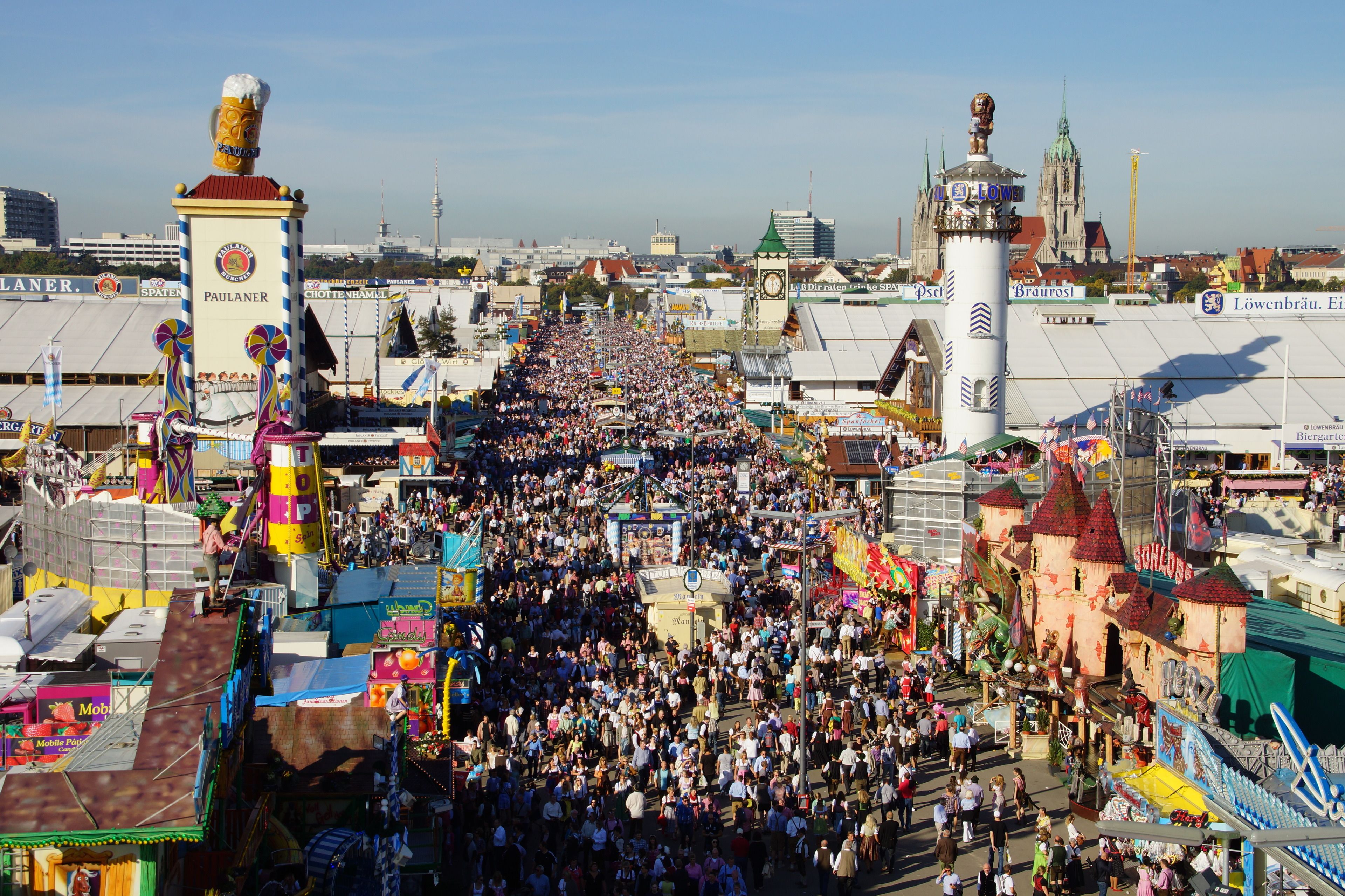 A crowded outdoor event with various stalls and a large crowd.