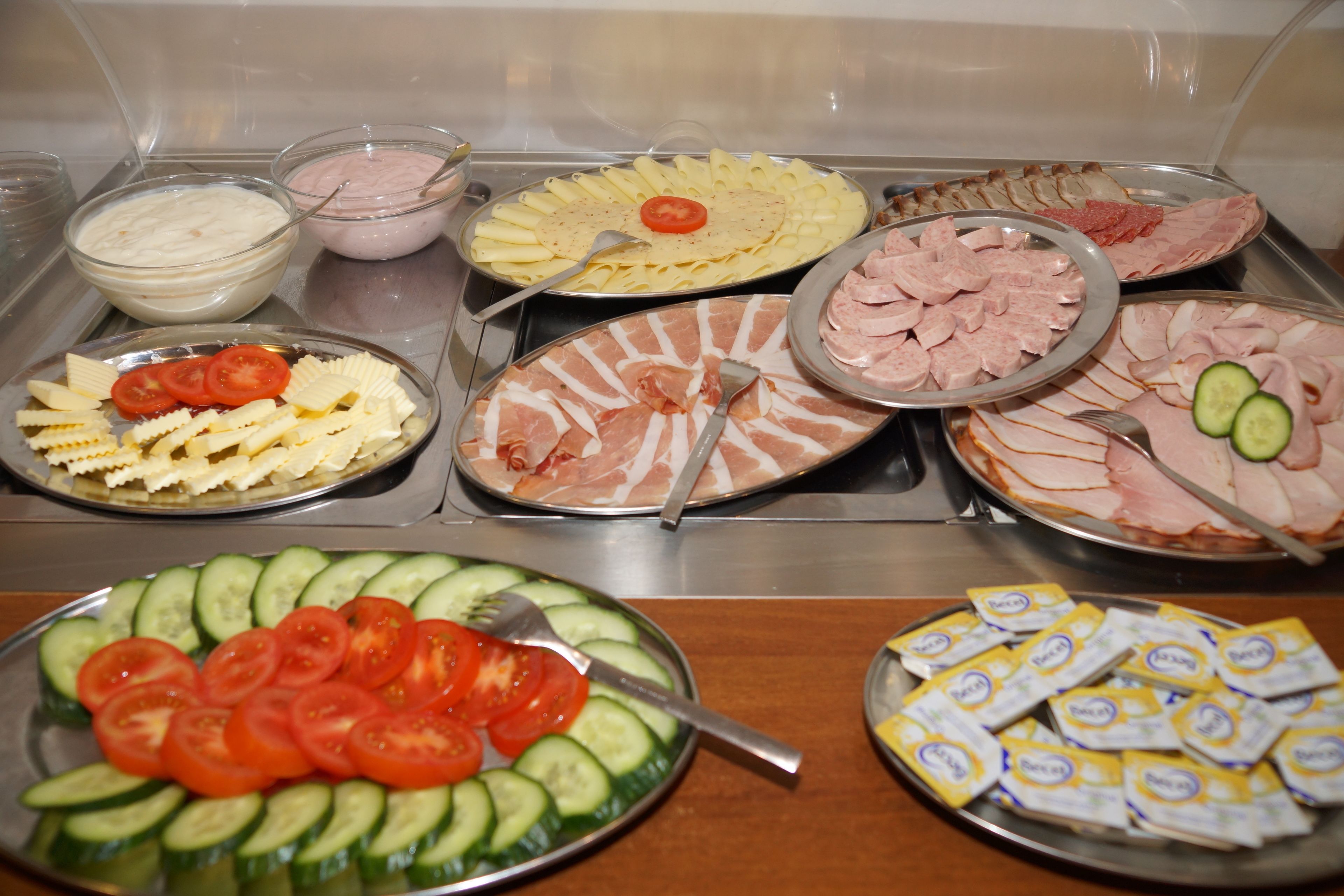 Un bufé con diversos alimentos, como pasta, carnes y ensaladas.