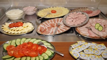 Un bufé con diversos alimentos, como pasta, carnes y ensaladas.