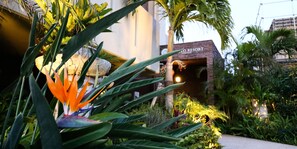 A resort entrance with a sign, lush greenery, and a well-lit pathway. - United Resort Yomitan (Yomitan)