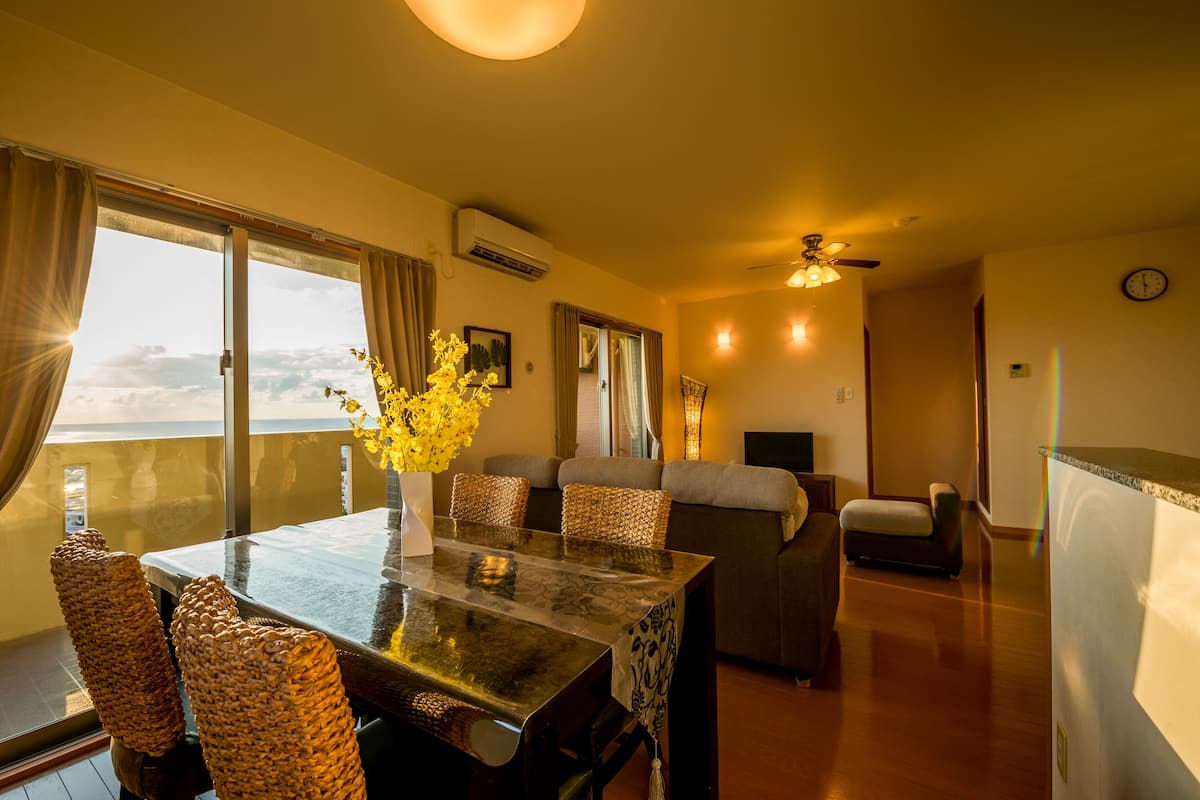 A dining area with a table, chairs, and a sofa.