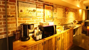 A kitchen with a brick wall, wooden cabinets, and various kitchen appliances. - Welcome Guesthouse Myeongdong (Seoul)
