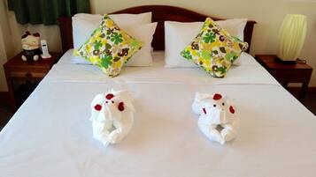 Restful retreat with a neatly made bed, featuring two decorative pillows and plush towels.