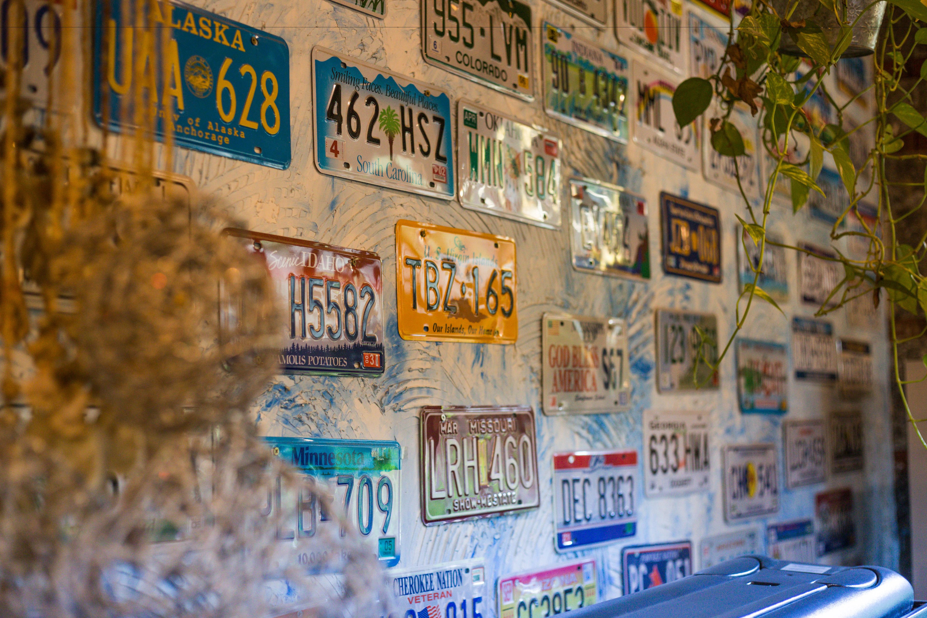 A wall covered with various license plates from different states.