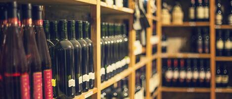 Estantes repletos de botellas de vino variadas.