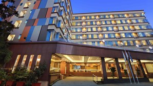 A multi-story hotel with a modern design, featuring balconies and a well-lit entrance. - Aston Inn Gideon Batam (Batam)
