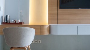 Una cocina moderna con horno integrado, cafetera y una botella de vidrio sobre la encimera.
