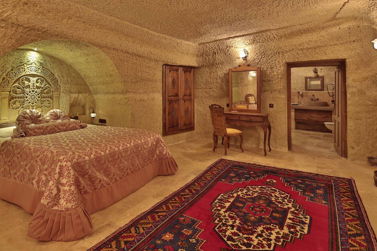 Una habitación con cama, escritorio, silla y un tapete grande.