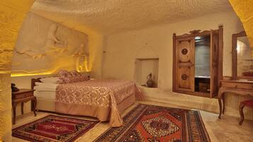 Un dormitorio con cama, mesita de noche, cómoda, espejo y estante en la pared.