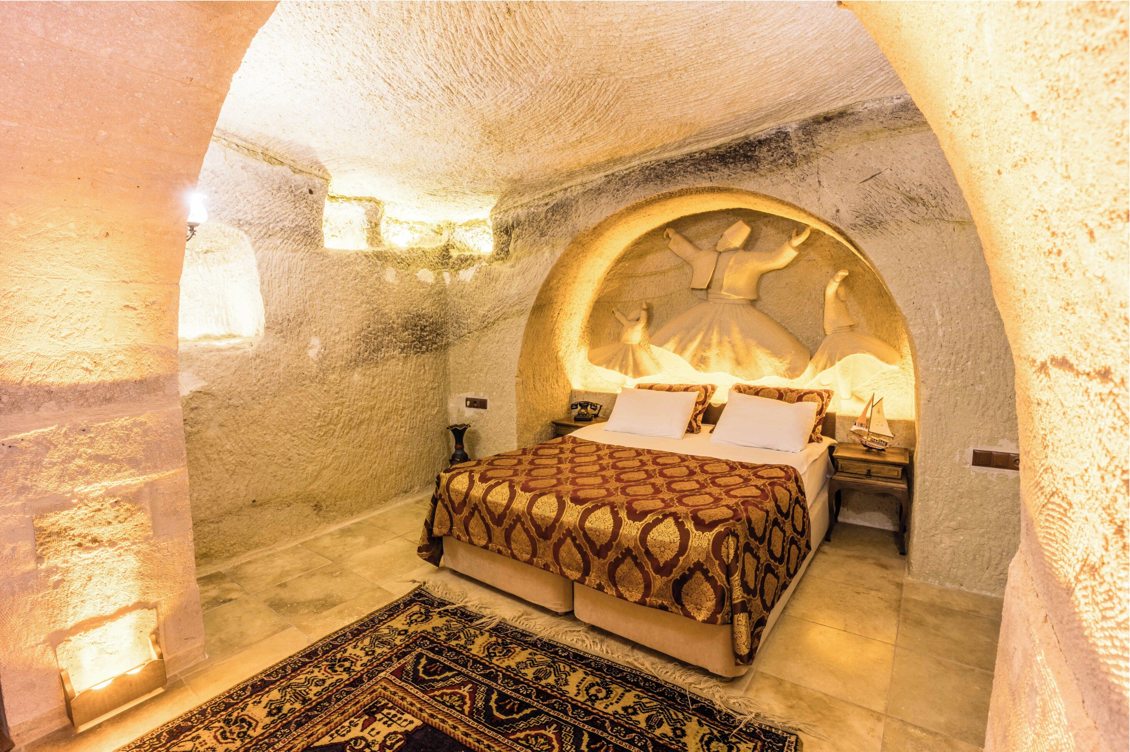 A room with a bed, a nightstand, and a wall with a circular design.